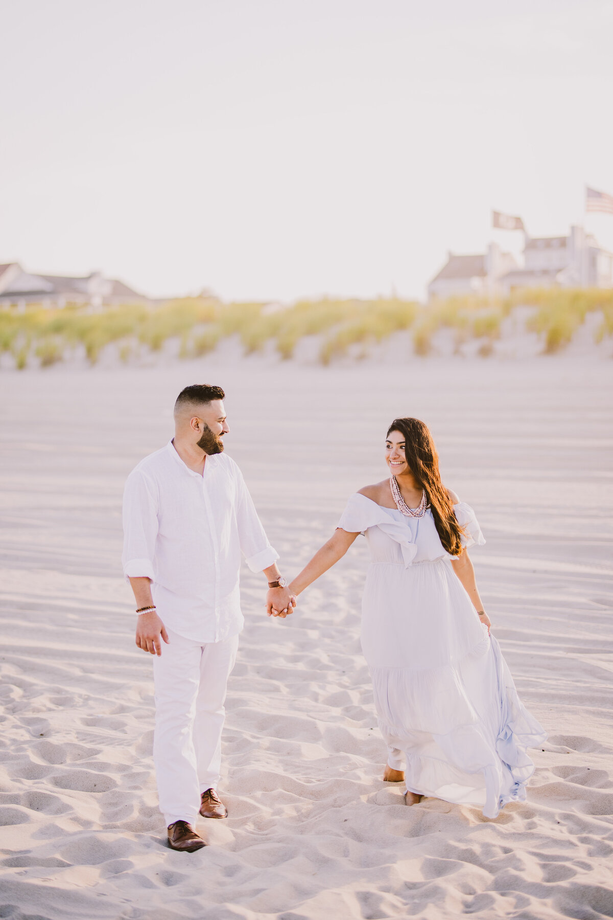 A couple walking through the bradley beach in jersey shore in nj in white outfits