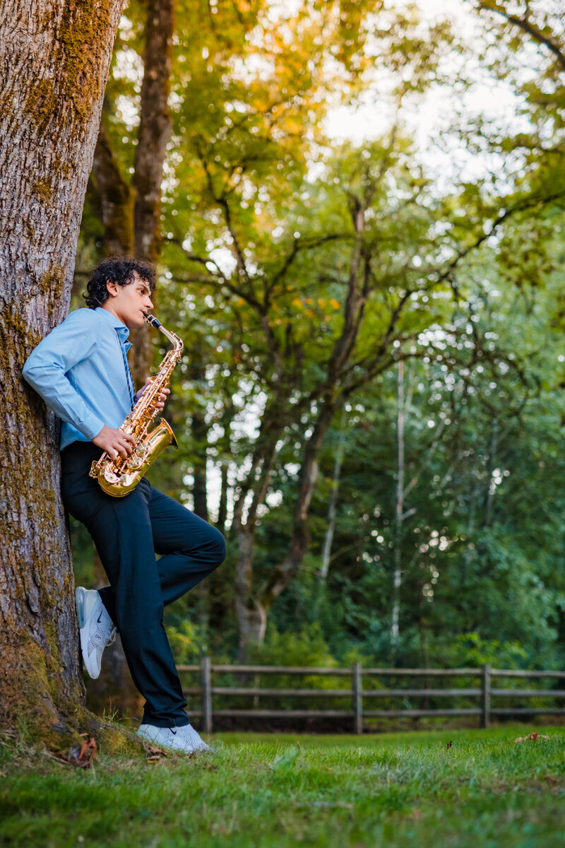 senior-portrait-playing-saxophone-against-tree