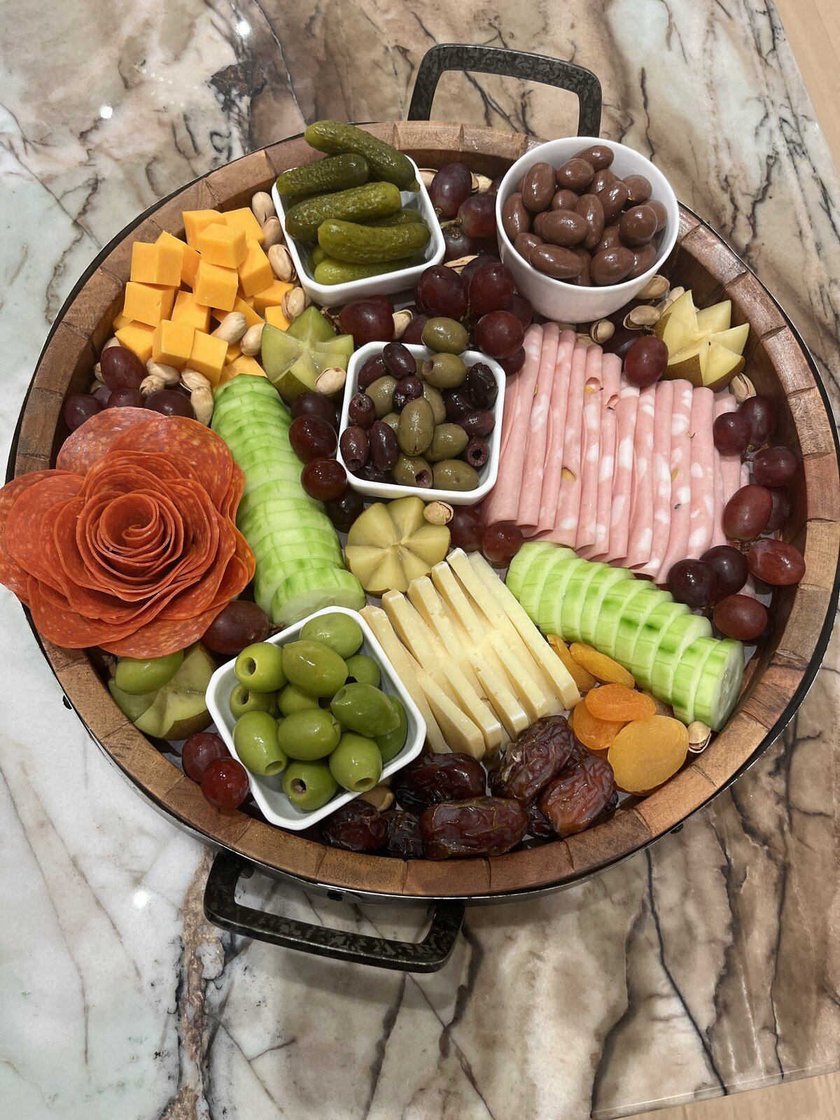 Round charcuterie board with meat and fruit