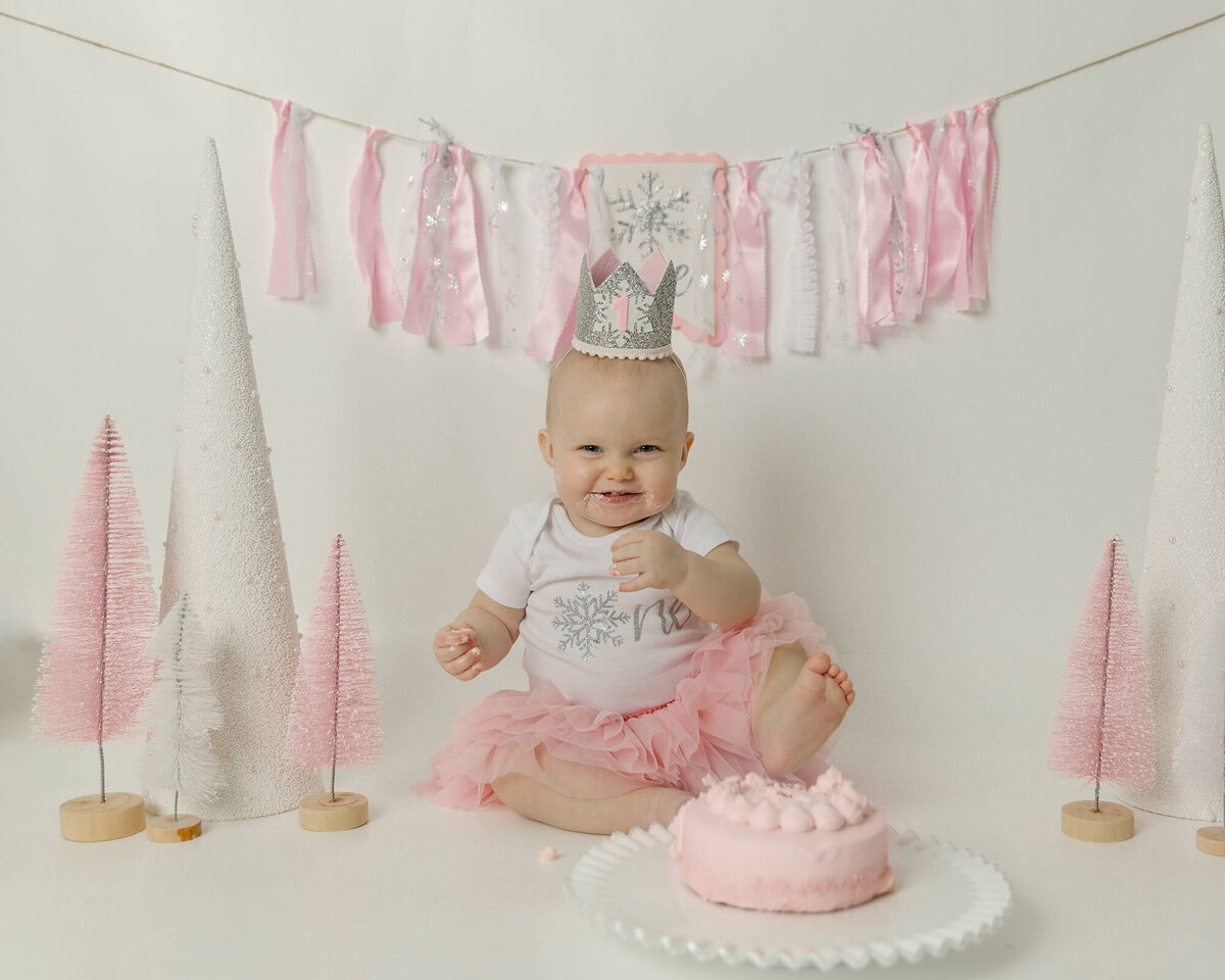 1 year old girl with birthday dressed in pink and white.