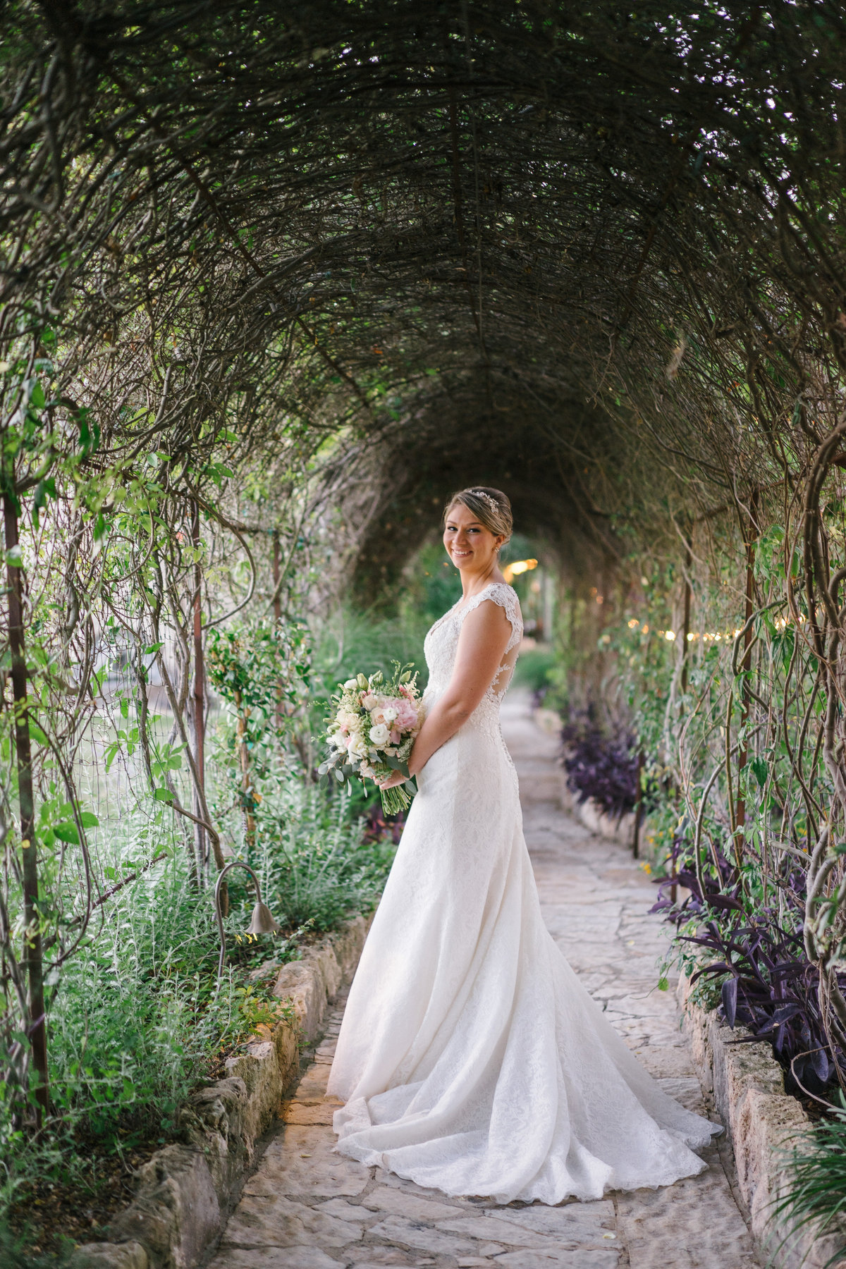 bride posing under arbor arch at Paniolo Ranch Event Center wedding venue