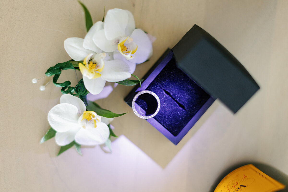 Andressa’s engagement ring displayed in a velvet box, surrounded by delicate white orchids, captured at Table Key, Islamorada by Claudia Amalia, destination wedding photographer.