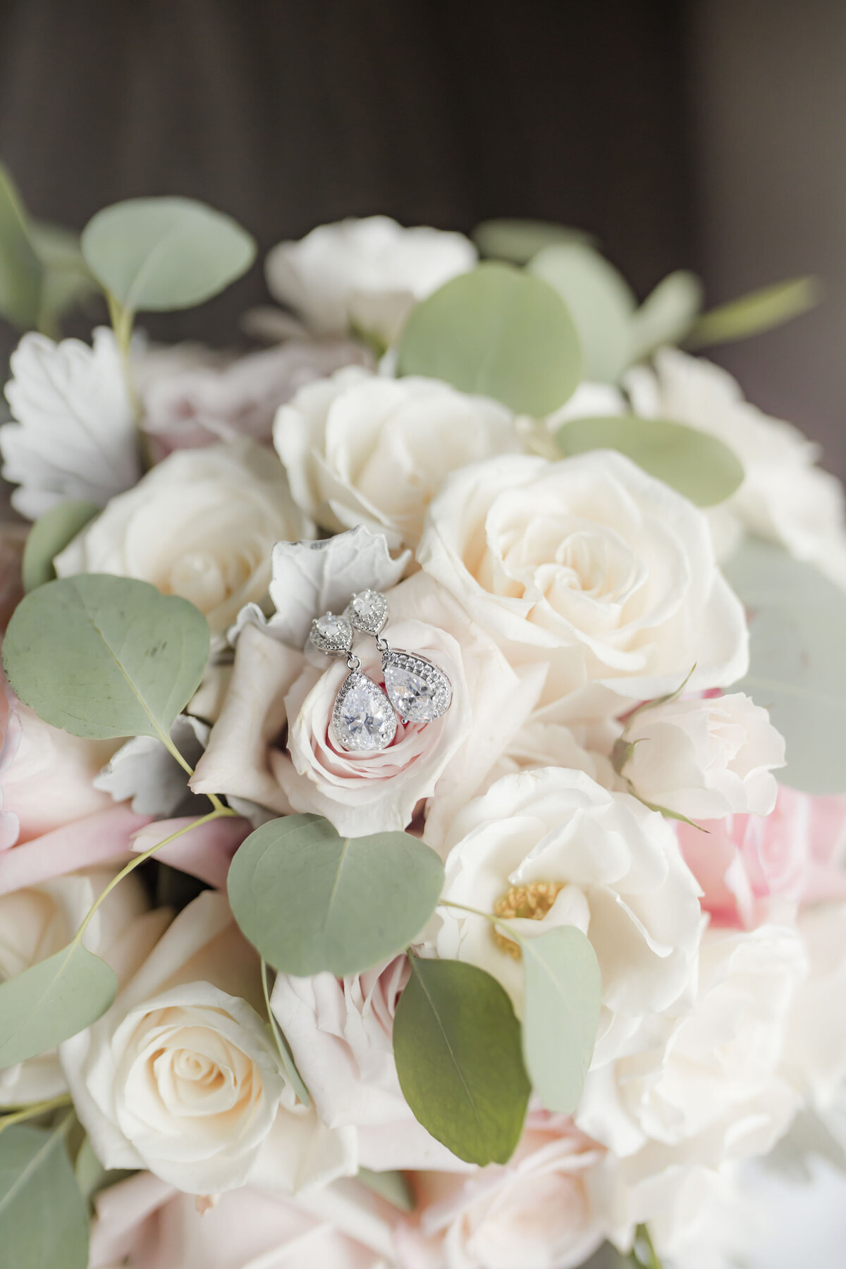 Wedding day earrings on top of bride's bouquet