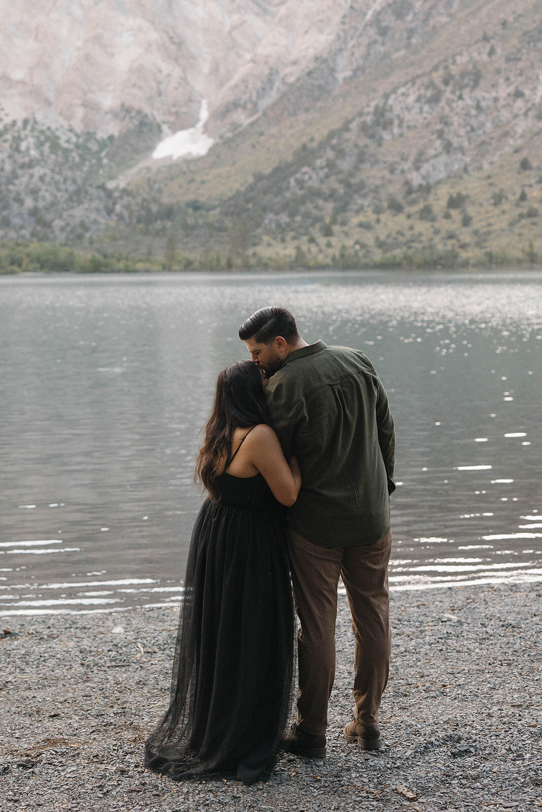 Couple hugging by a mountain lake