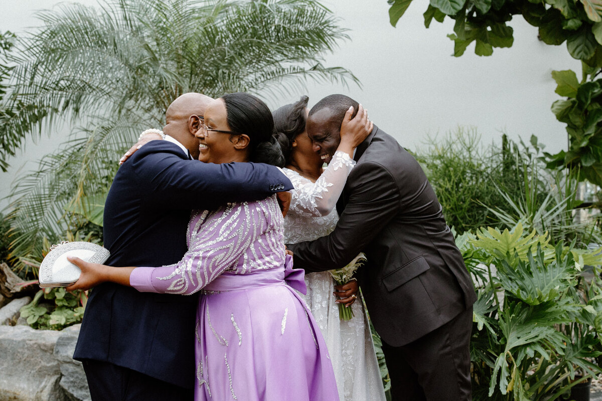Bride and groom hugs their family after their greenhouse wedding