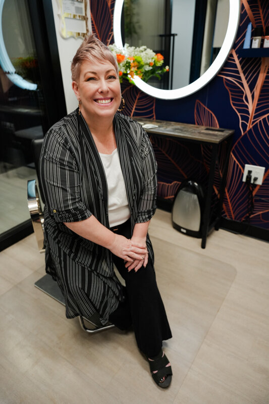 Hairdresser in her salonchair smiling at camera