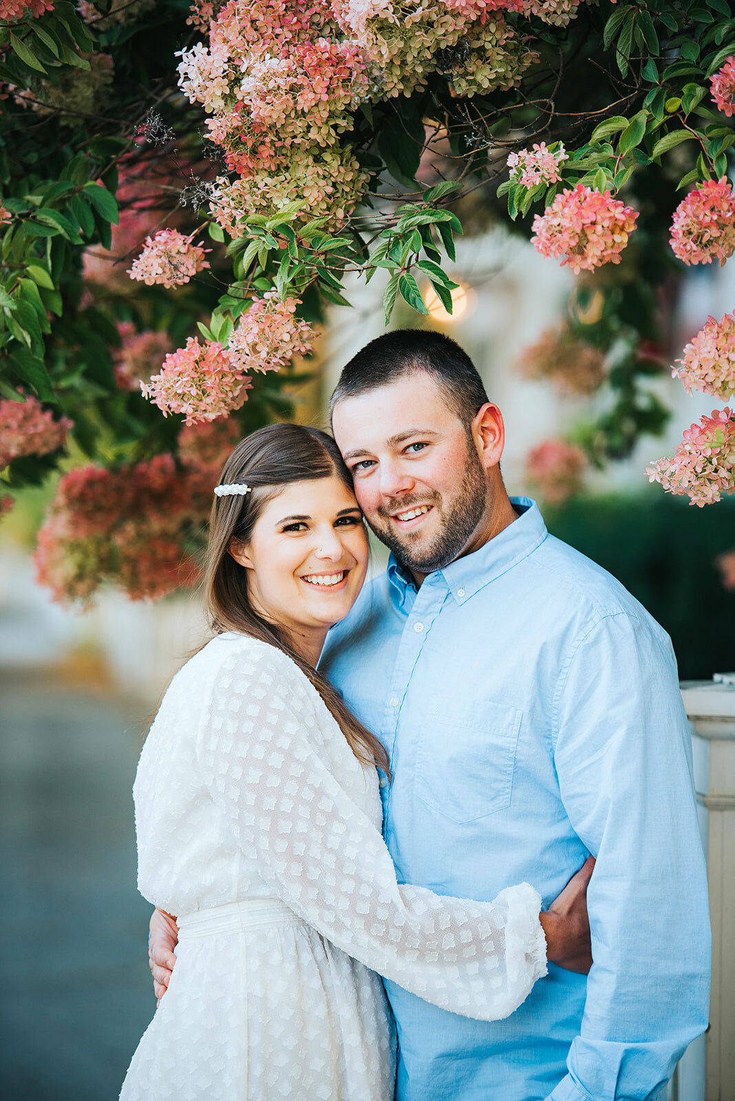 engaged couple with hydrangeas at woodstock inn vermont