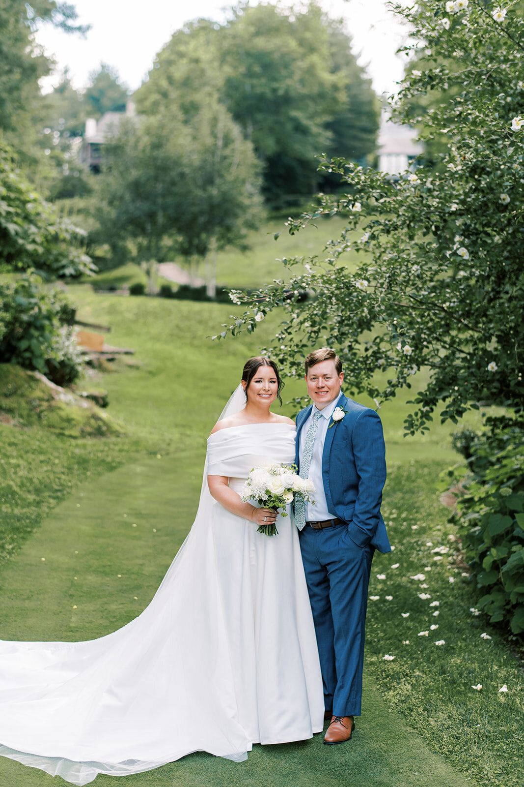 Classic outdoor wedding portrait of bride and groom surrounded by lush greenery in Cashiers North Carolina.