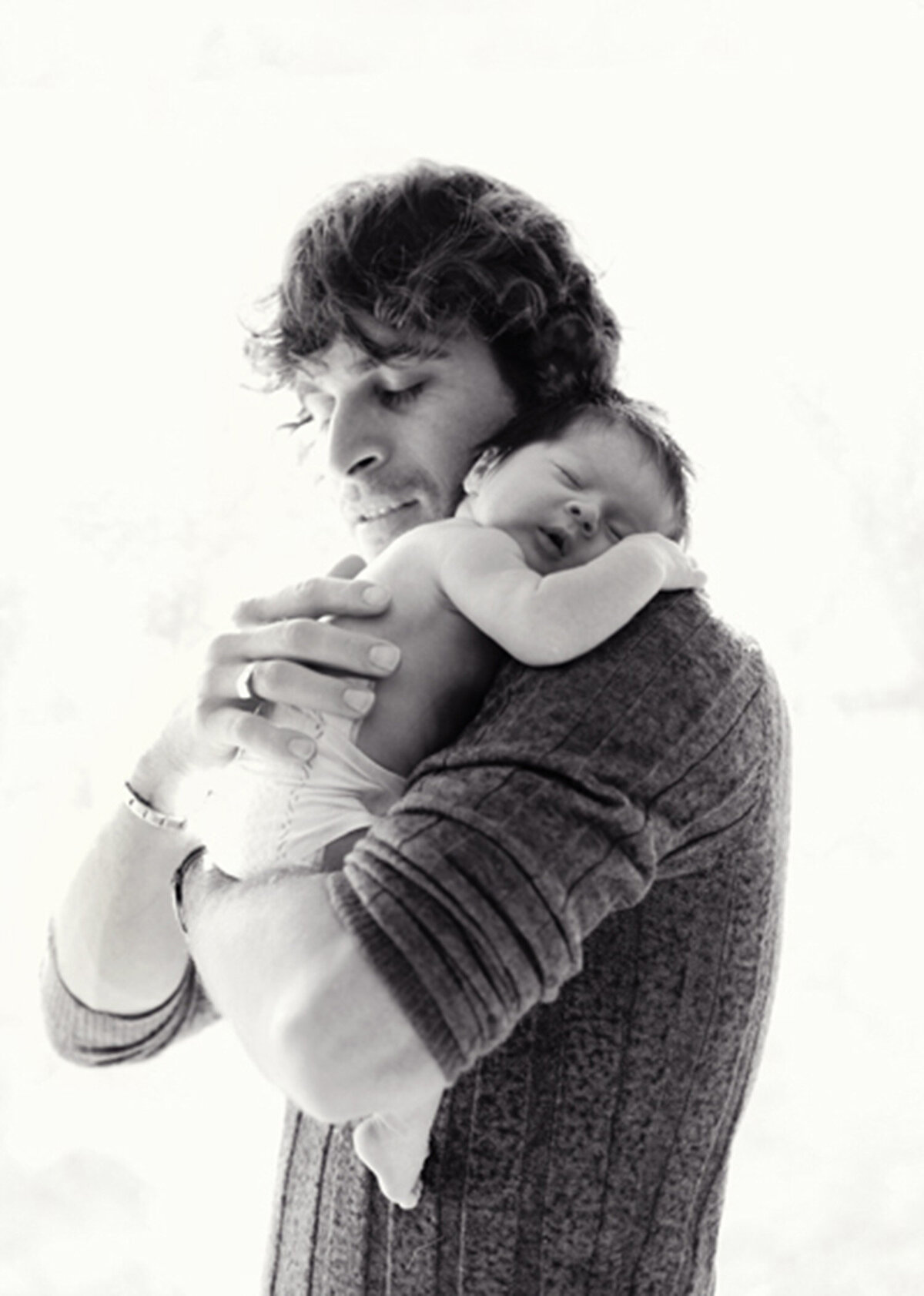 Father holding newborn by window — natural light in San Francisco Bay Area home