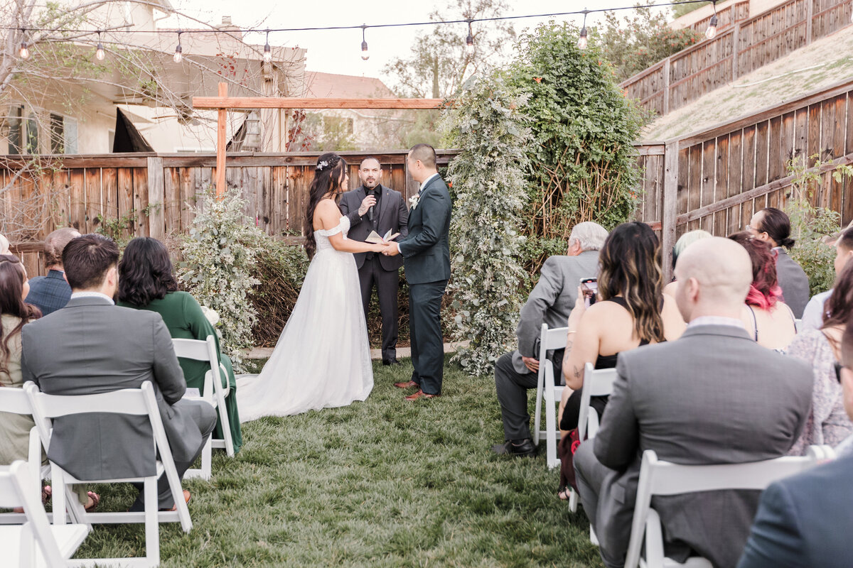 Bride & groom exchange vows during the ceremony in a private backyard wedding in the Inland Empire