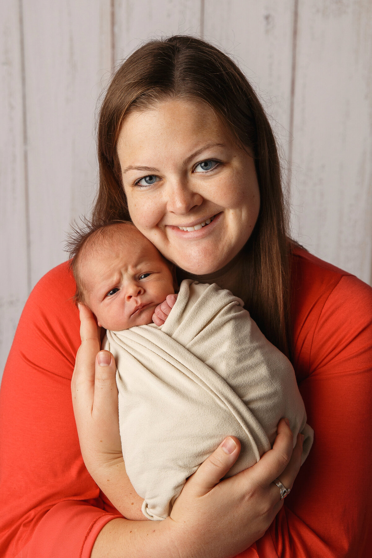 Portrait of a smailing mom holding her newborn baby