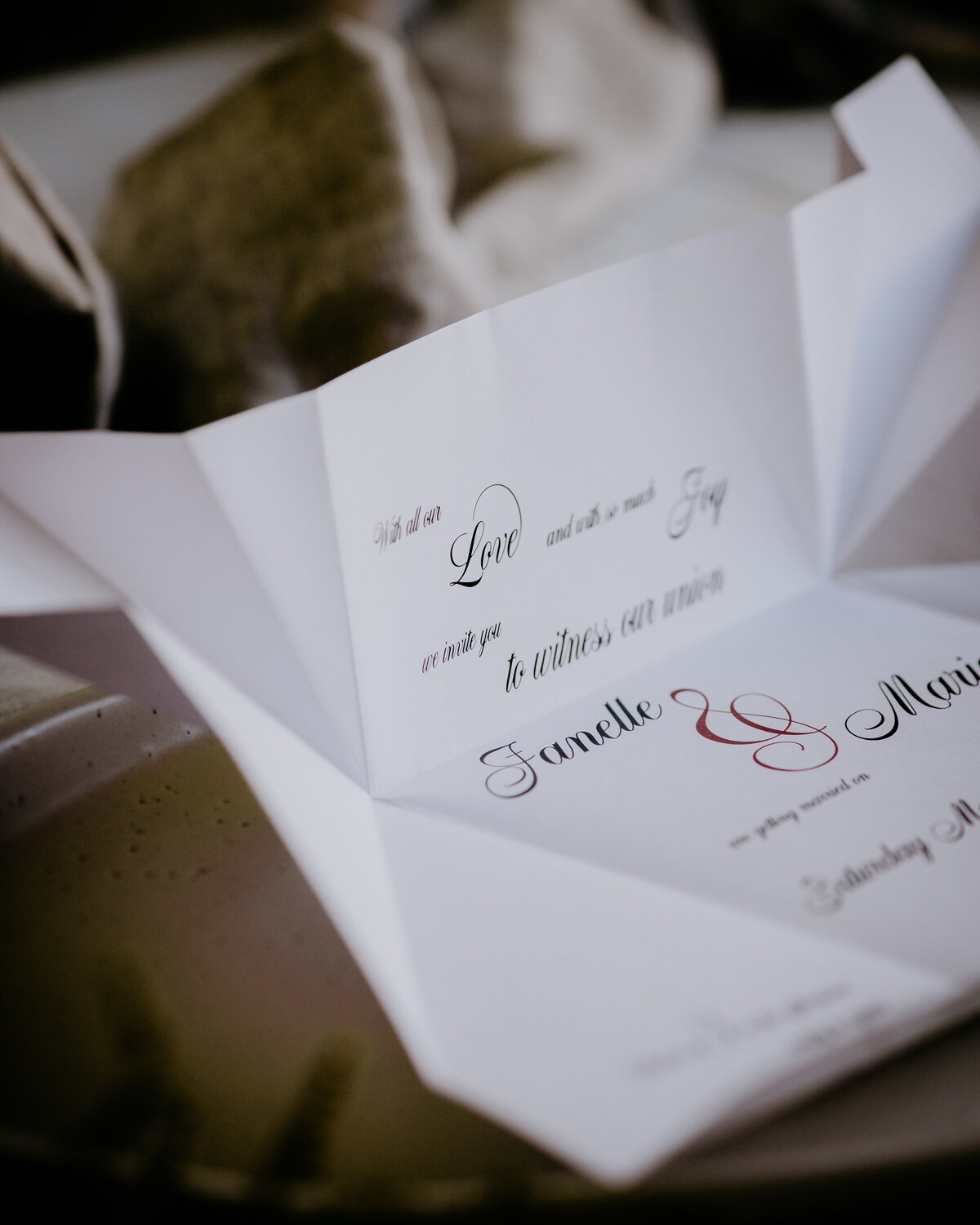 Folded origami wedding invitation with cursive font
