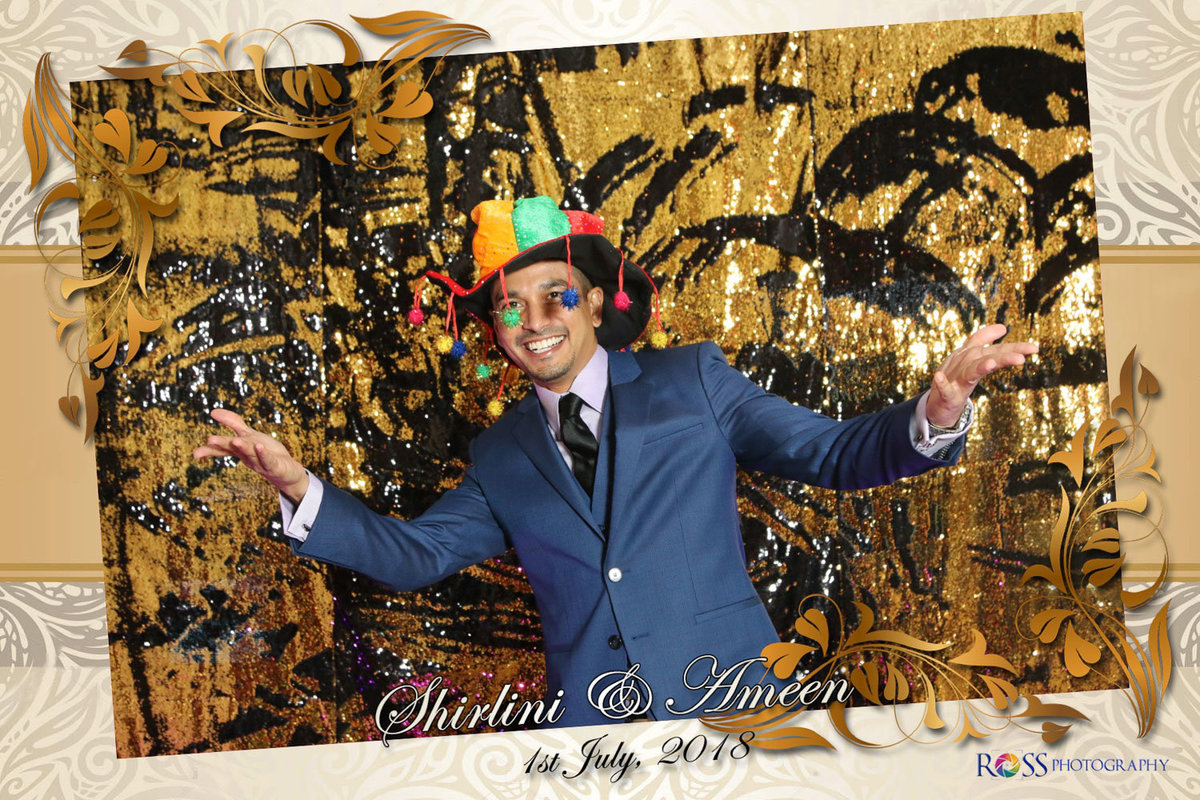 A fun loving man wearing a multicoloured hat with tassels. Photobooth by Ross Photography, Trinidad, W.I..