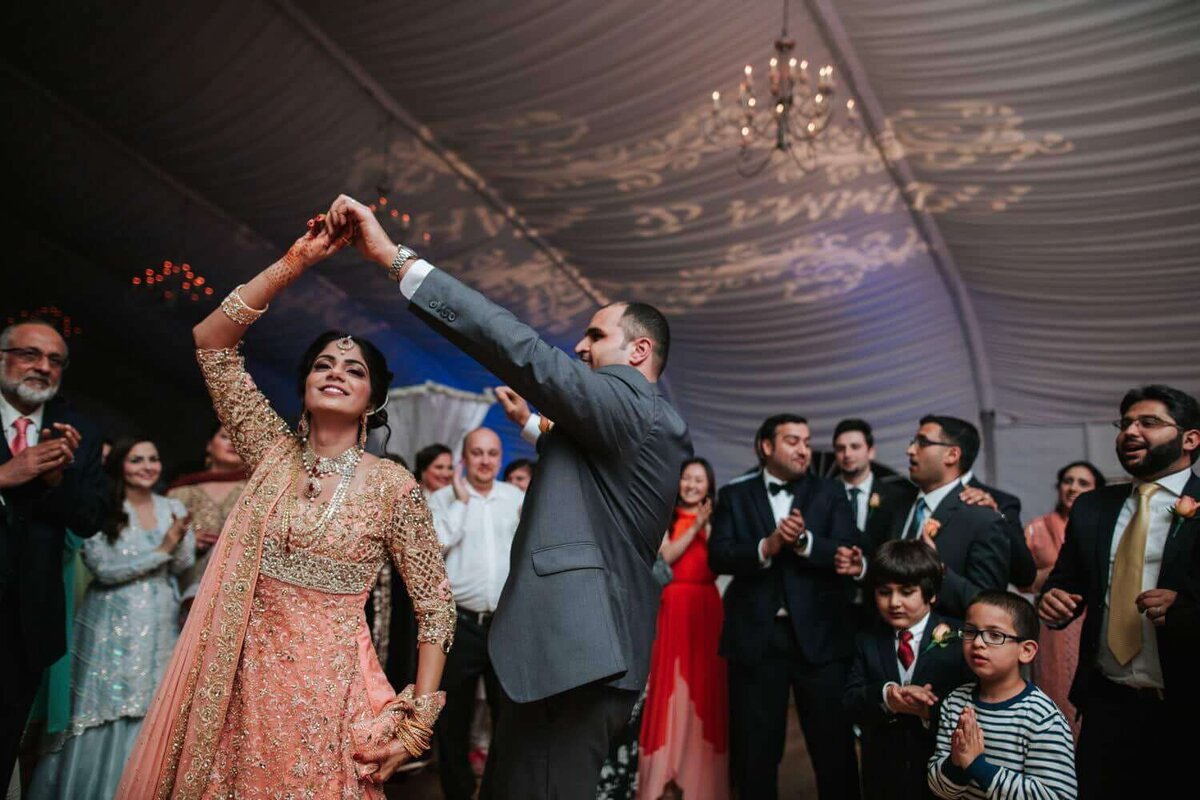 Philadelphia South Asian bride and groom dancing surrounded by friends and family.