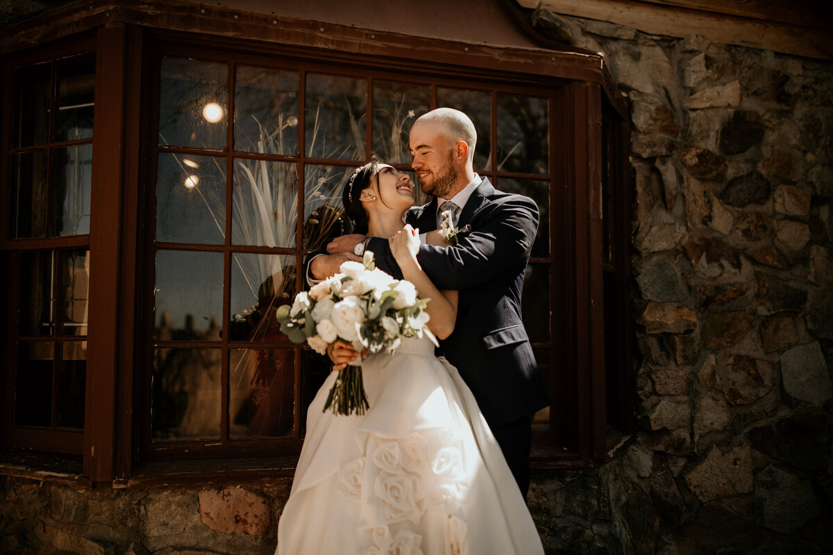 groom holding bride from behind at brewery venue