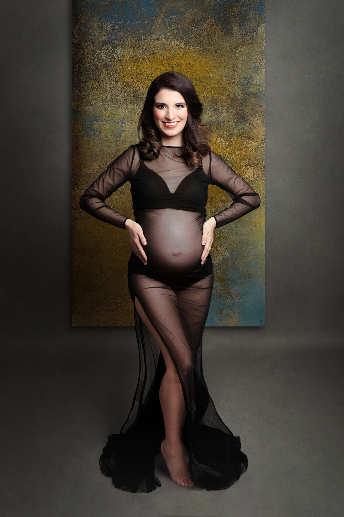 pregnant mother wearing a black sheer gown  at her maternity photography photo shoot