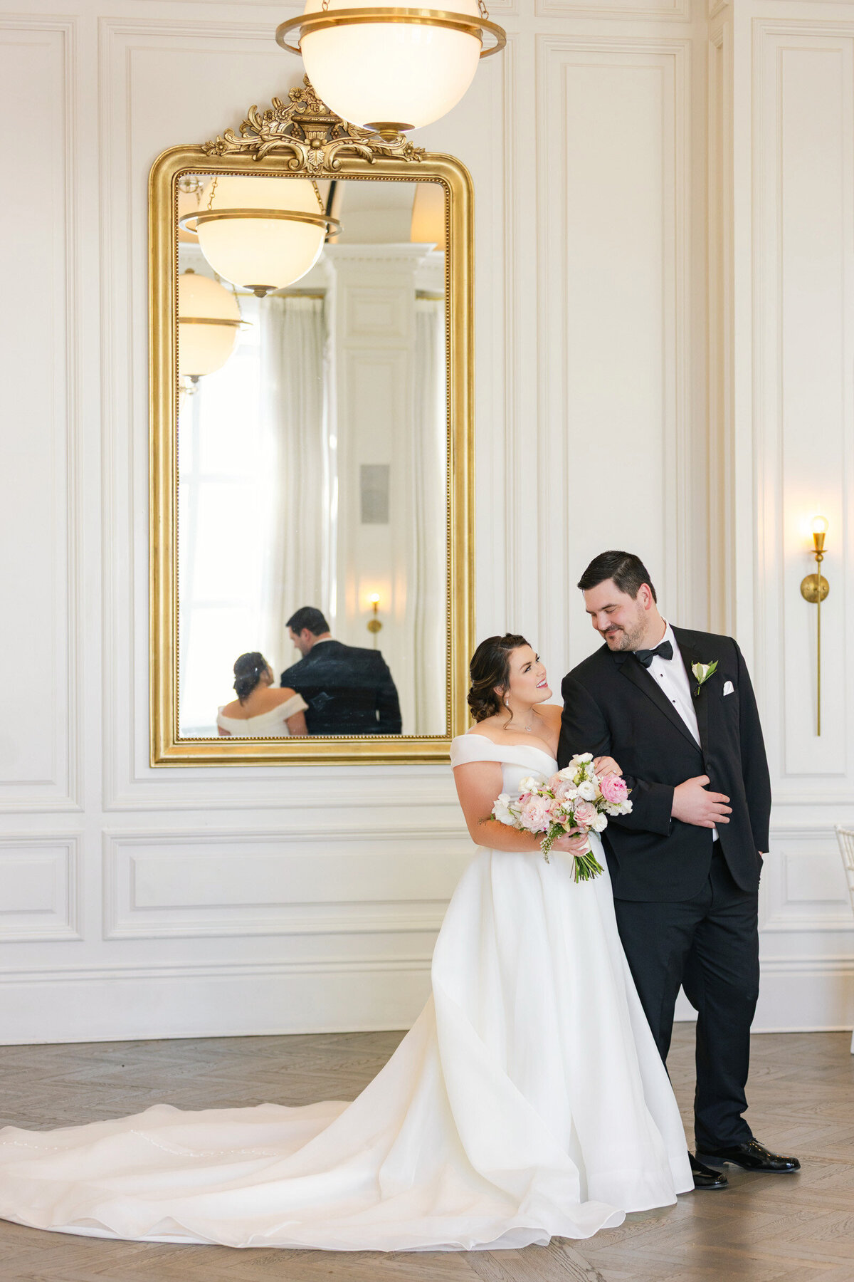 Bride and groom standing together in the Governor’s Room at The Adolphus in Dallas, looking at each other in a simple and timeless portrait that reflects the style of weddings at this venue.