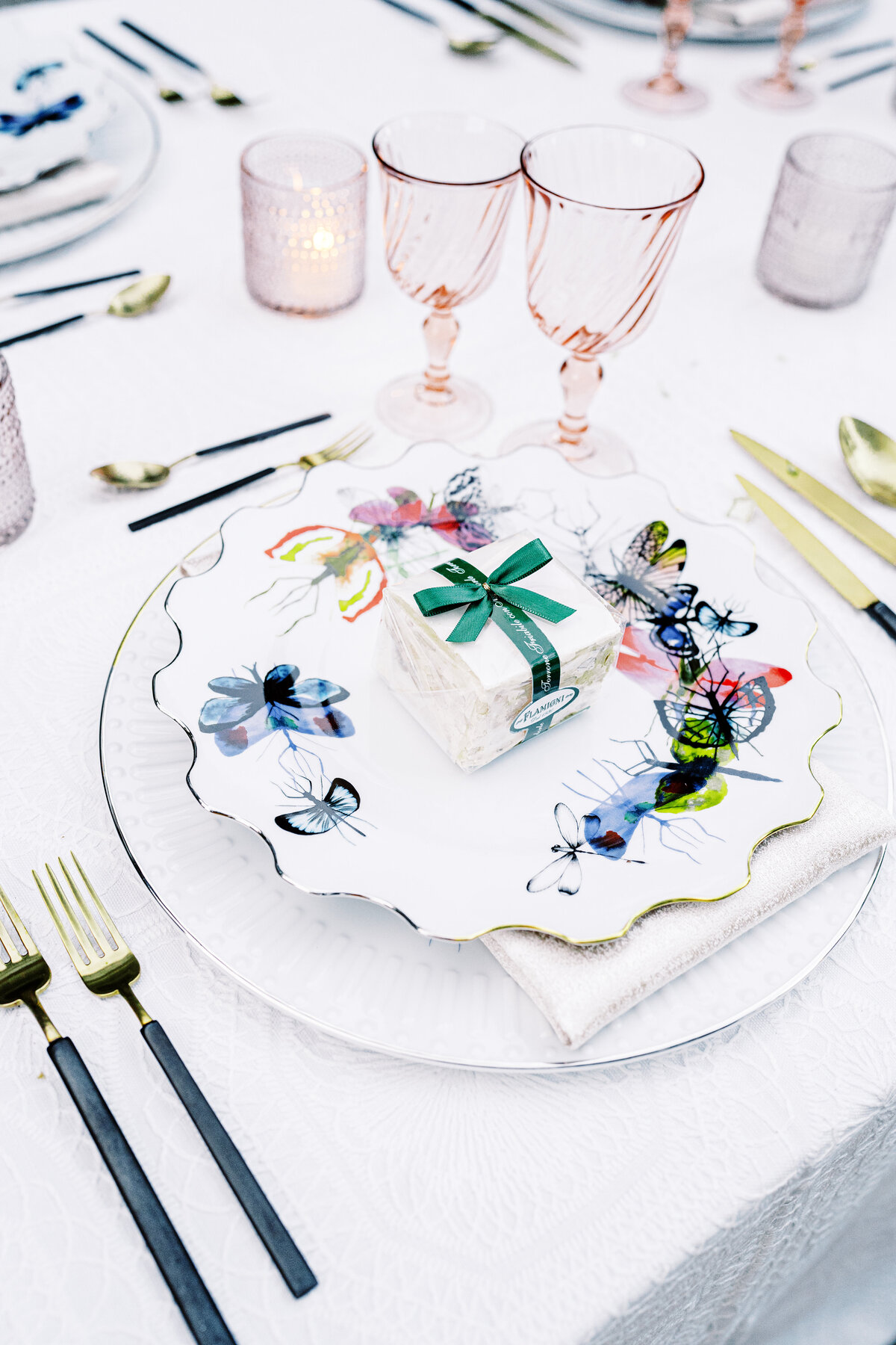 Lake Como wedding reception table of colorful butterfly plates, gold and black utensils photographed by Lake Como Wedding photographer