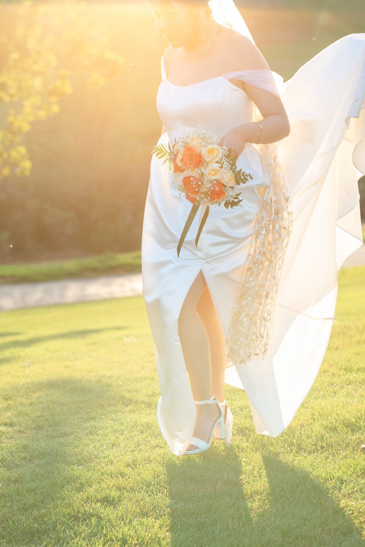 Bride holding a flower walking in a beautiful garden