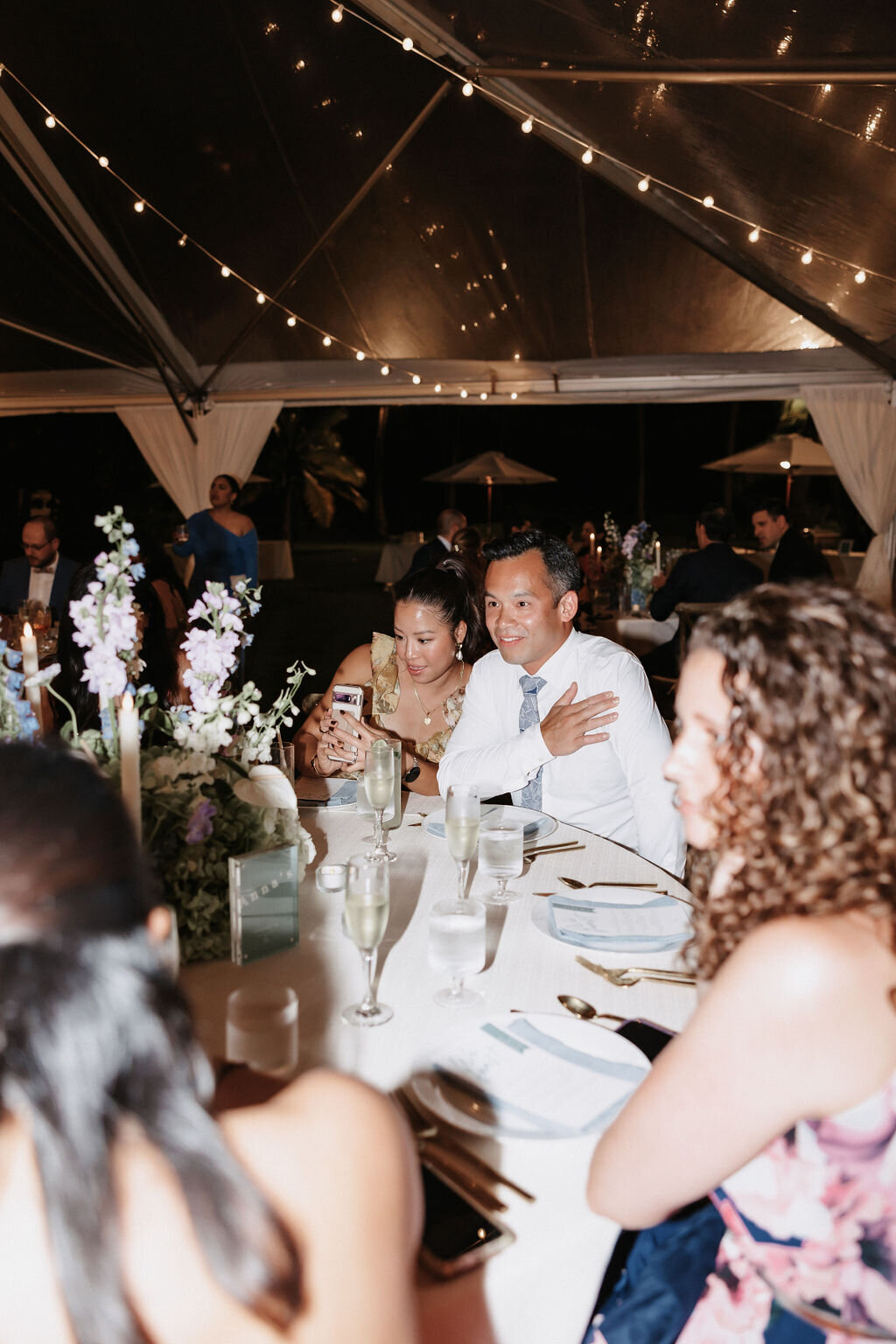 wedding guest candid photo under clear tent at lanikuhonua