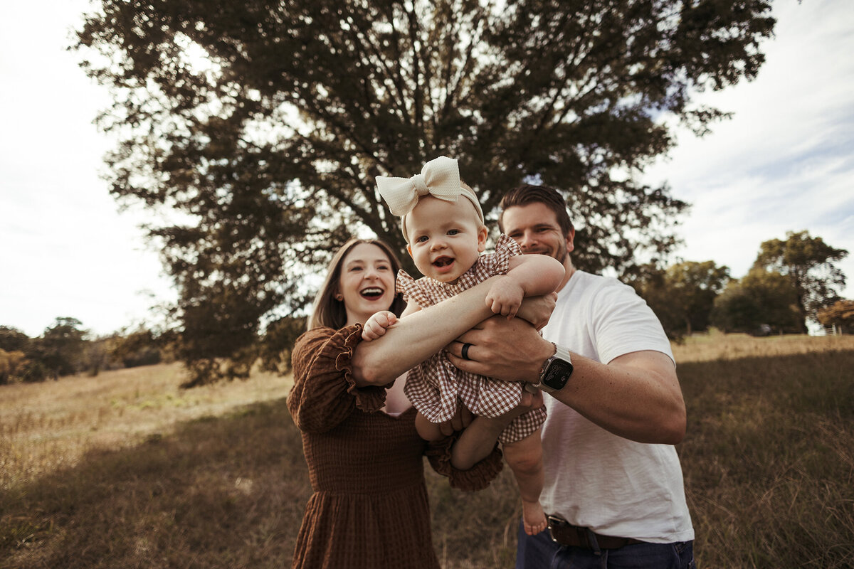 Family photography, family of four standing closely together with hands on each other