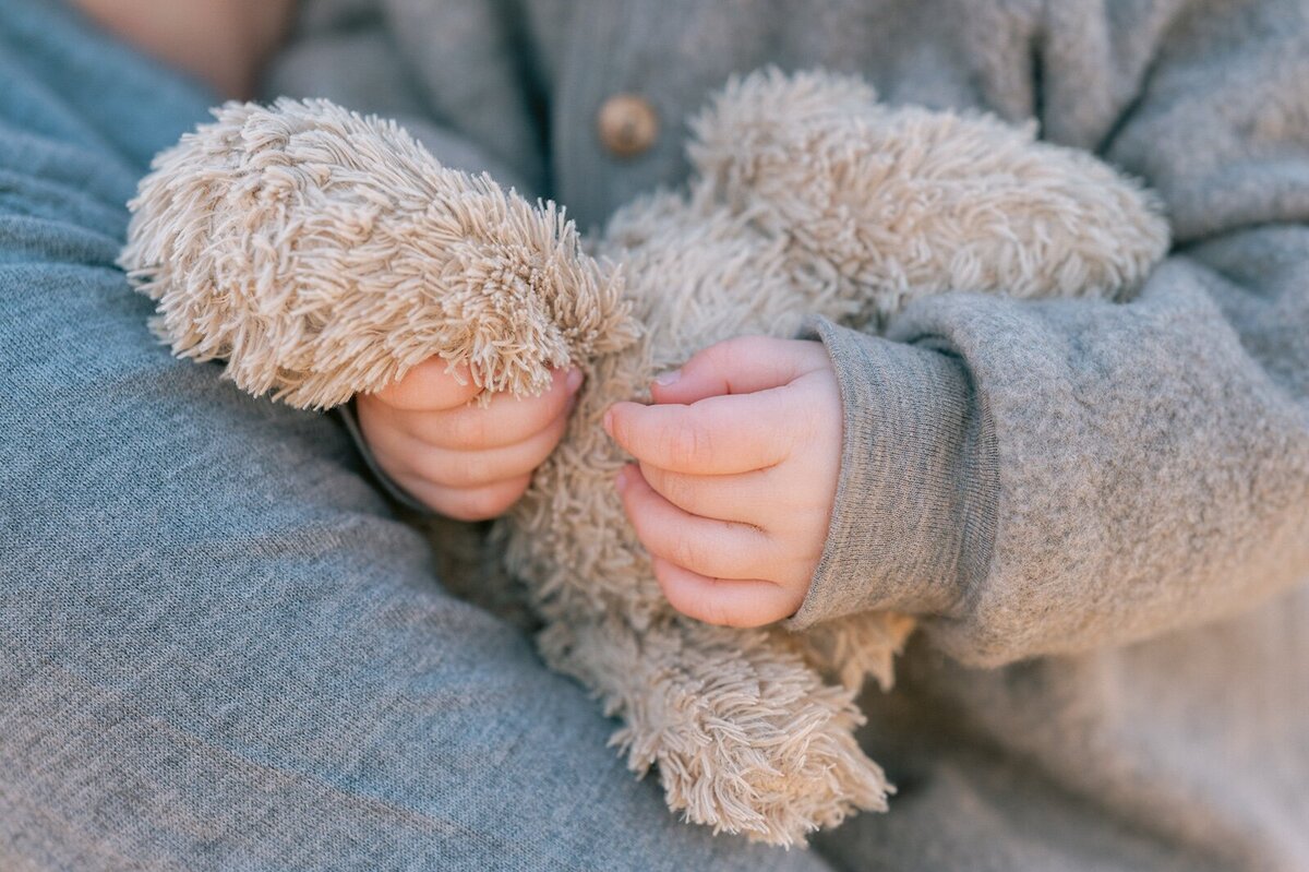 Kinder handje met knuffel beer er in