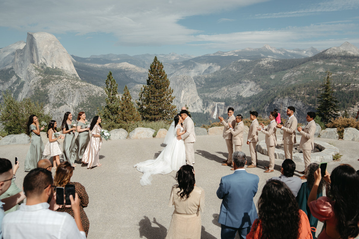 Glacier Point Amphitheater Wedding  with guests seated in the amphitheater and Half Dome in the background