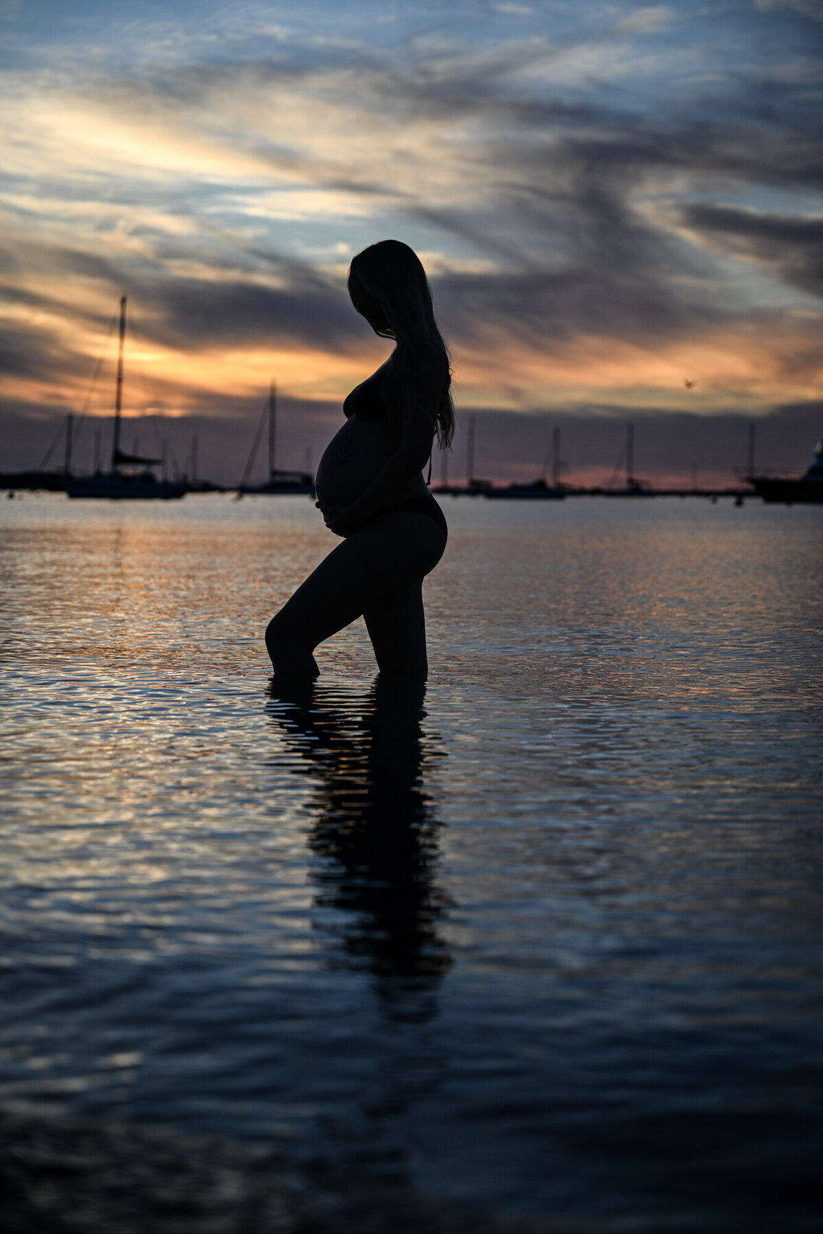 Silhouette of pregnant mam during a maternity photo session at the beach