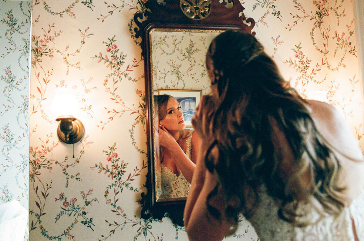 Bride preparing to wear her earrings