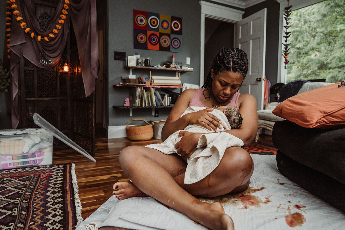 Mother holds her newborn at a home birth in Portland, OR