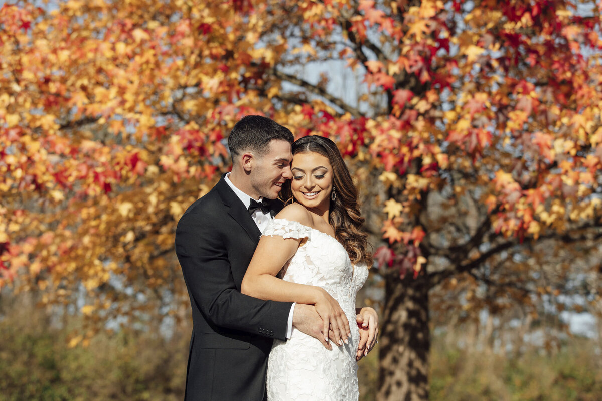 The Farmhouse | Groom hugging bride outdoors during fall wedding | Hampton, New Jersey