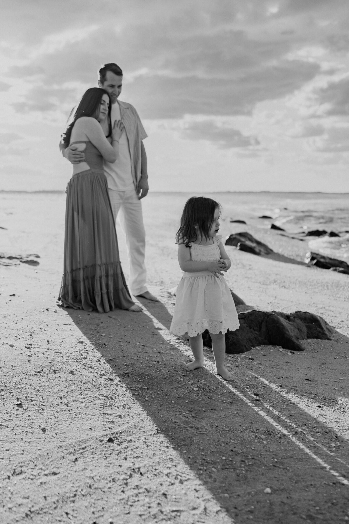 Family standing on the beach watching the waves