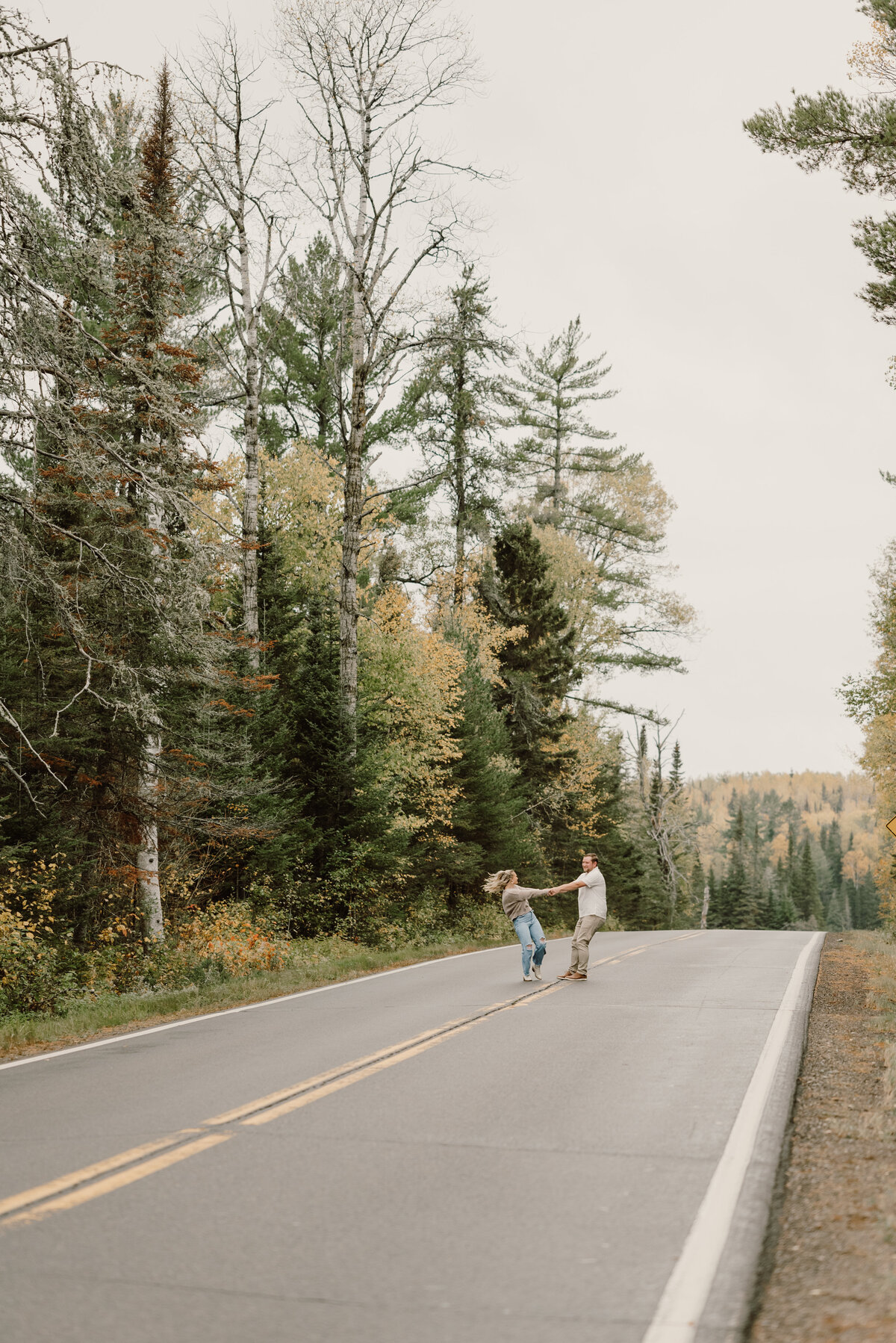 girl and boy spin in middle of the road