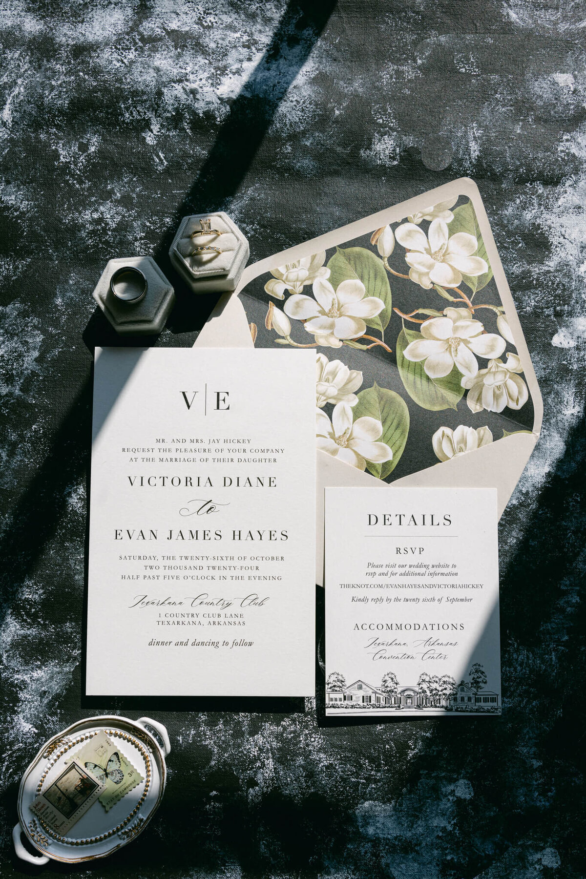 A wedding day photo of the brides rings and wedding invitations
