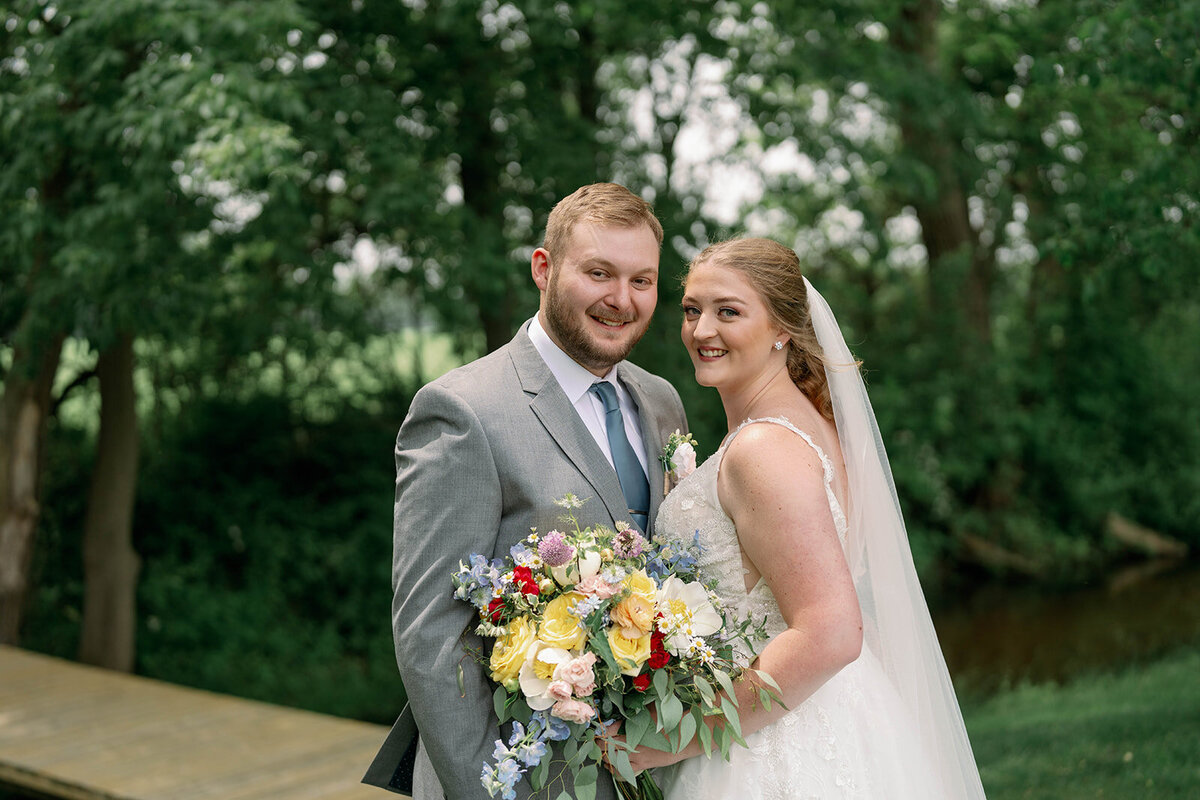 Timeless wedding portrait of the bride and groom smiling together at The Blue Heron Barn venue.
