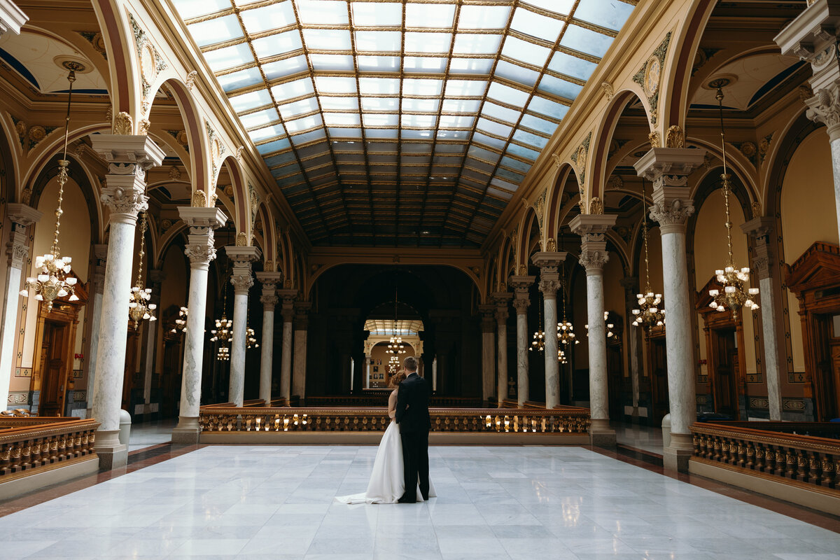 Bride standing in a grand architectural hall, photographed by Ryann B Photography, specializing in elegant Indiana weddings.