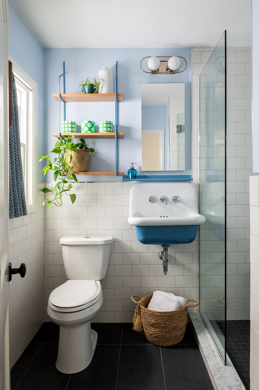 open door to white shower room with wood and blue accent