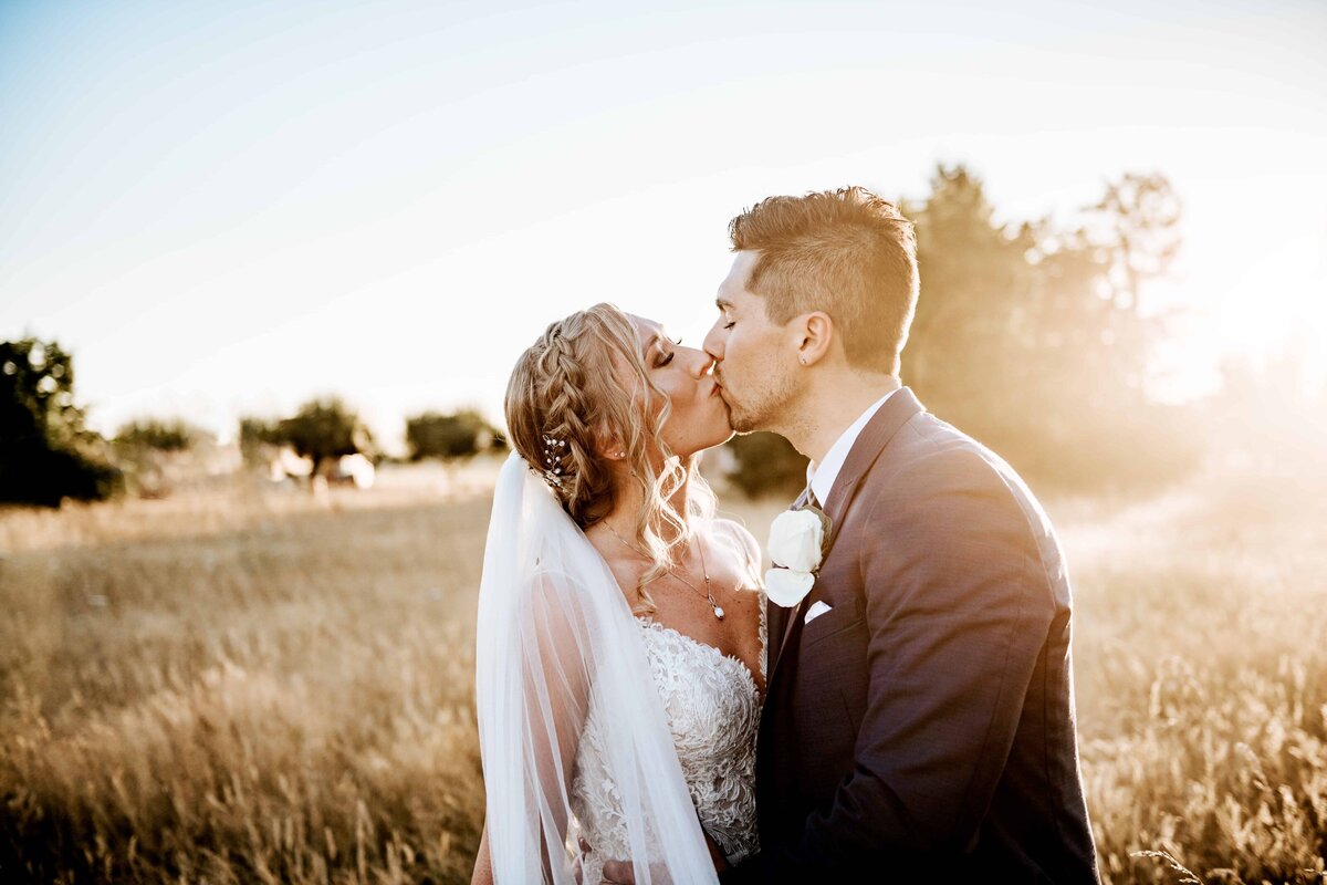 bride and groom kiss at sunset