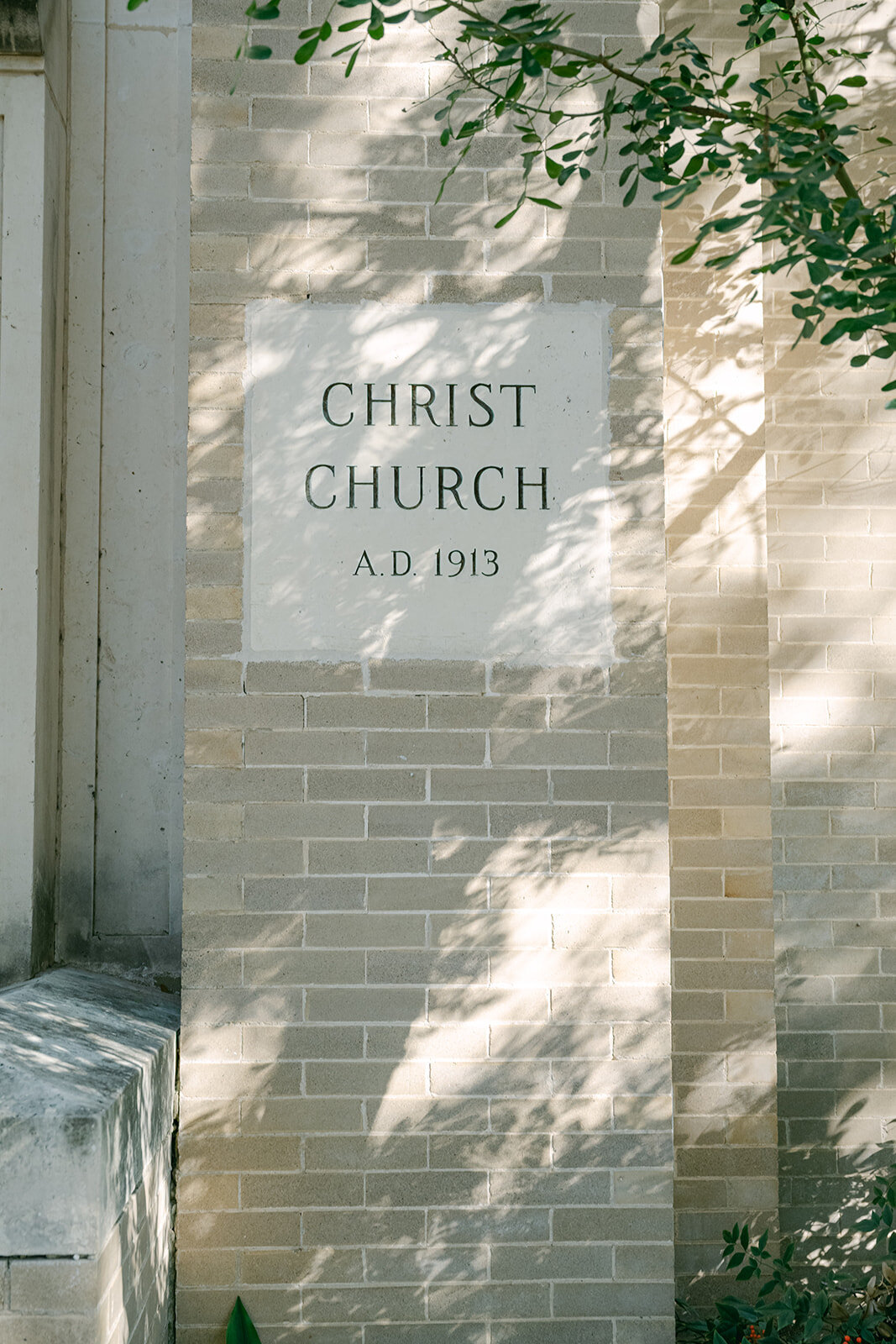 Stone engraving at church entrance captured with editorial styling during elegant San Antonio wedding