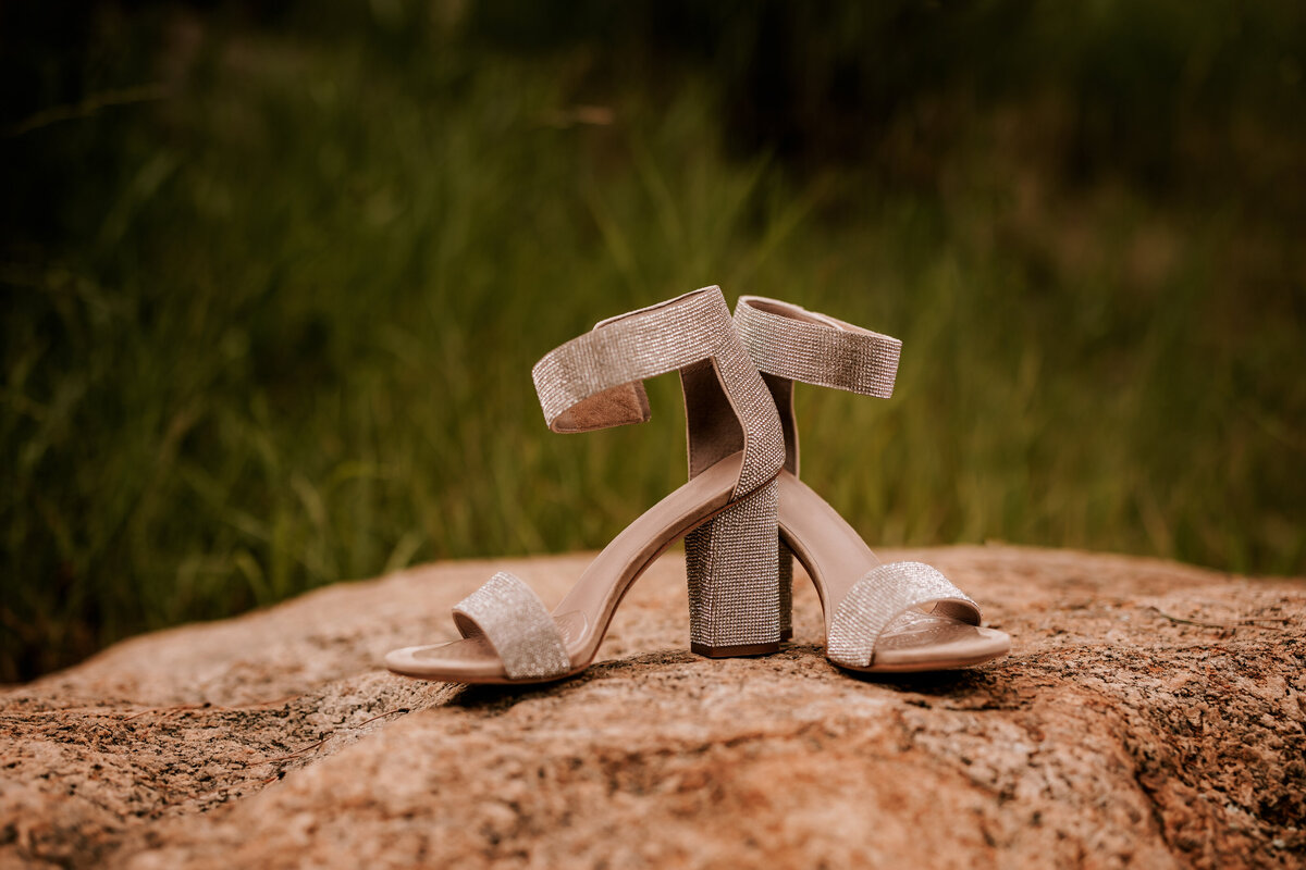 Gold bridal shoes perched on a rock