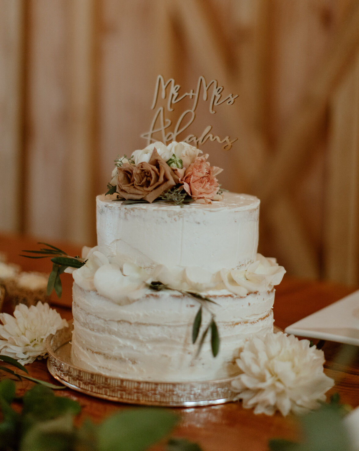 Terra cotta and white flowers accenting the wedding cake.