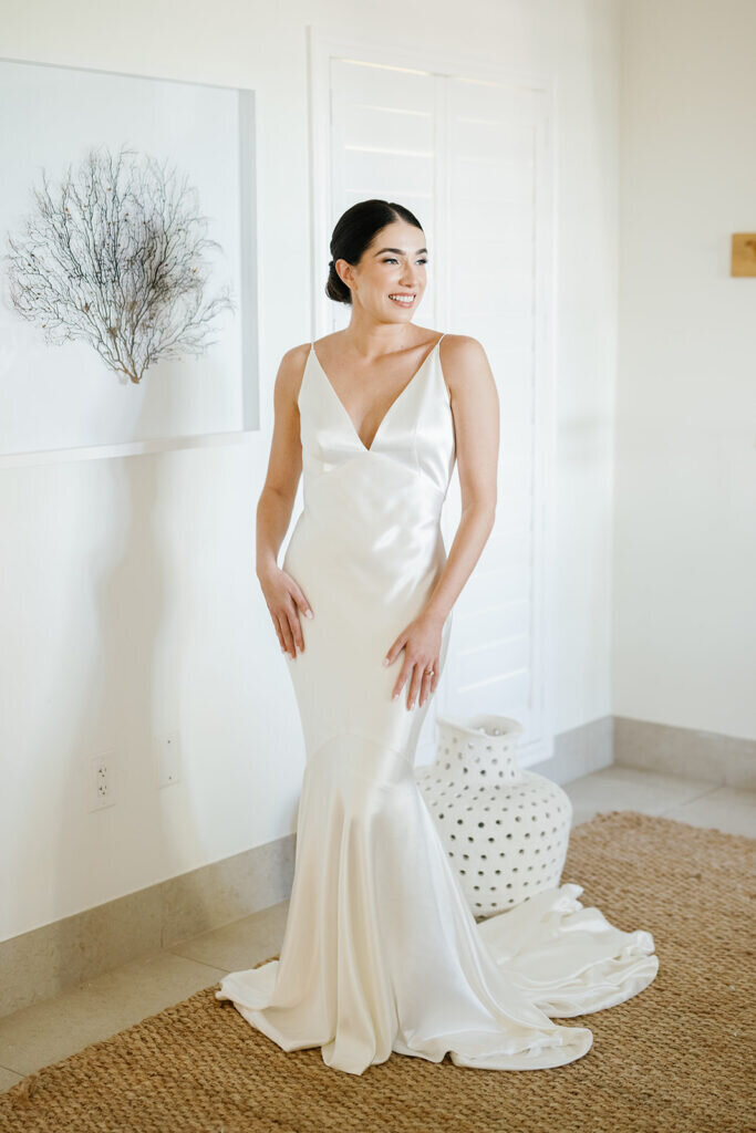 The bride stands gracefully in a minimalist, modern wedding gown with delicate details, exuding elegance. Captured by Florida Keys wedding photographer Claudia Amalia Photography.
