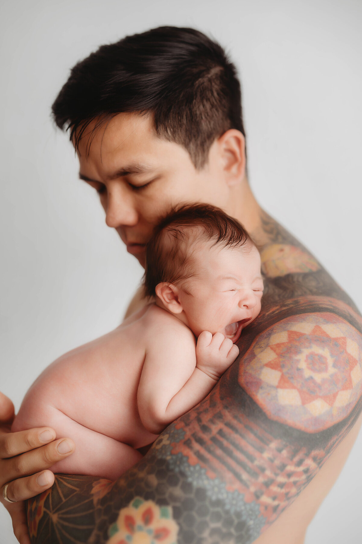 Father poses with his infant daughter during Newborn Photos in Asheville, NC.