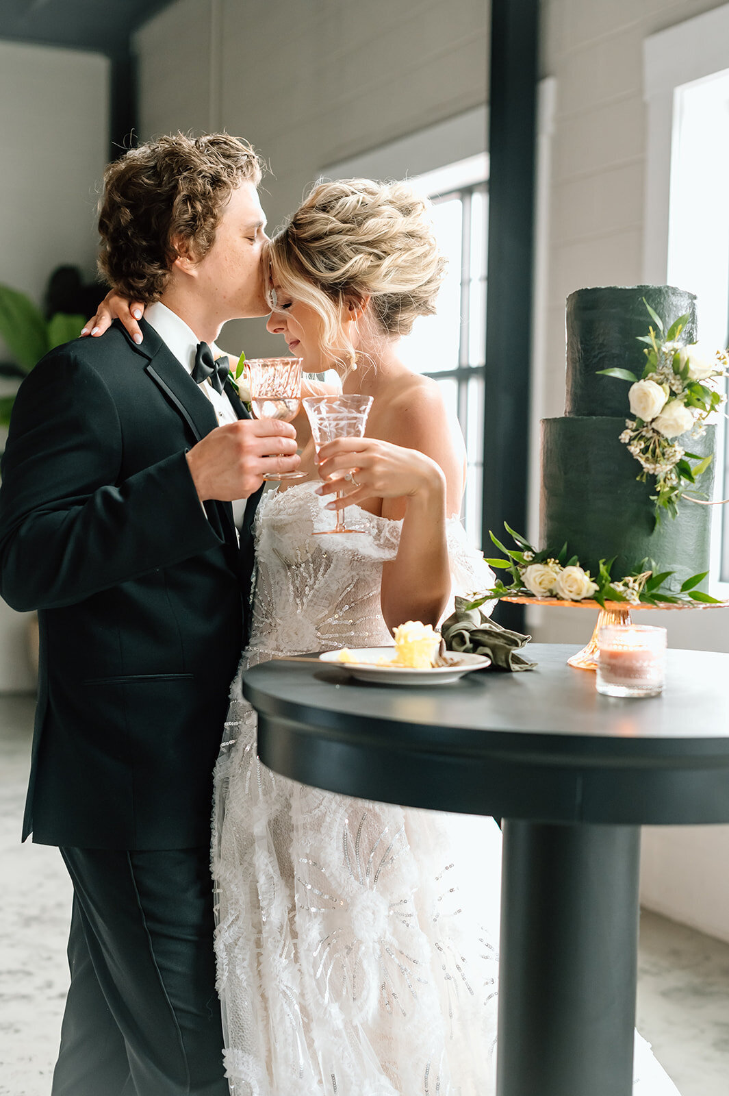 Newlywed couple toasting at their elegantly decorated reception table, surrounded by flowers and love, as they celebrate their covenant in Christ.