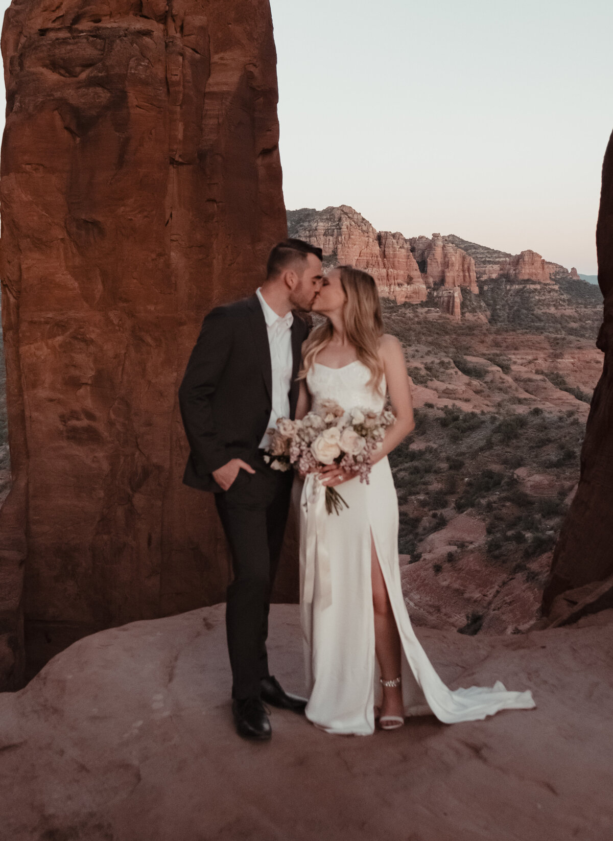 Groom carrying bride along trail Sedona elopement taken by Kollar Photography