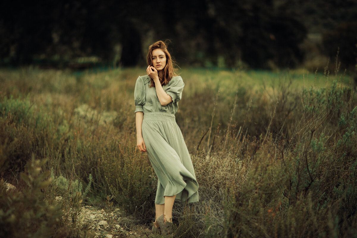 Portrait Photo Of Young Woman In Green Dress Standing In The Middle Of a Meadow Los Angeles
