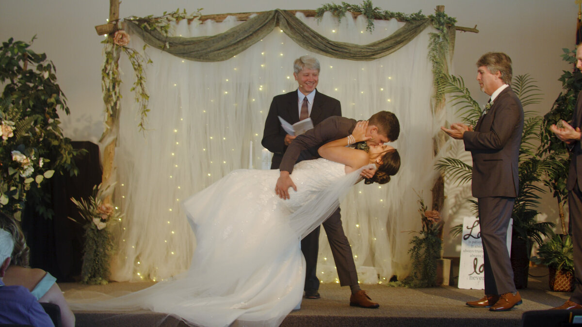 A couple dramatically kissing at the altar of their L:ehigh Valley wedding.