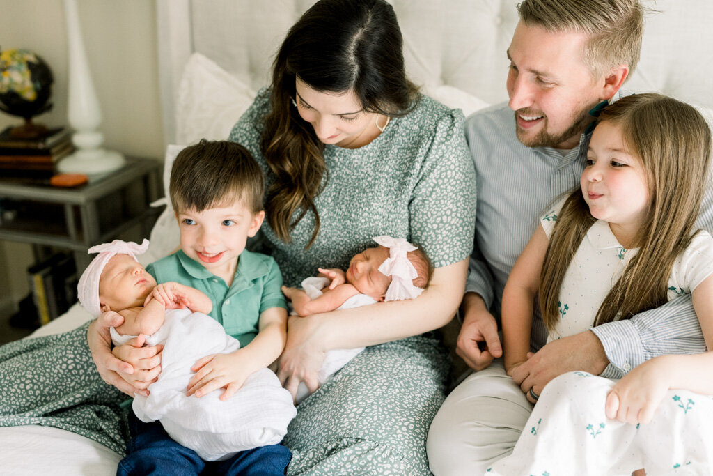 Family of six snuggling newborn twins