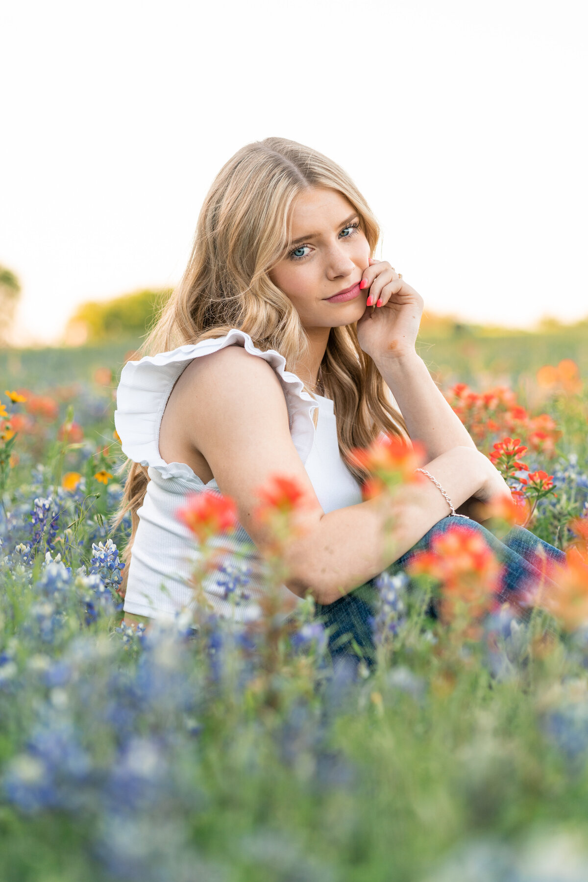 High school girl with casual outfit in the wildflowers for senior photos. In Austin Texas.
