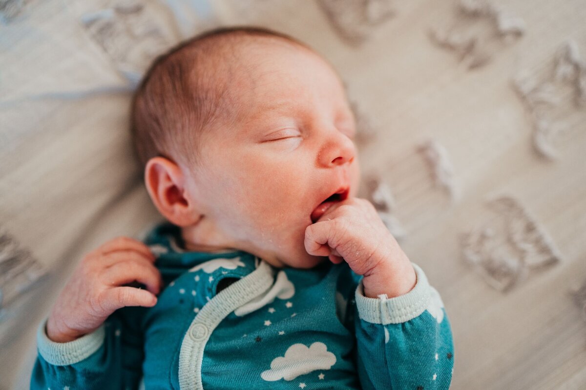 newborn-baby-girl-relaxing-in-her-bed